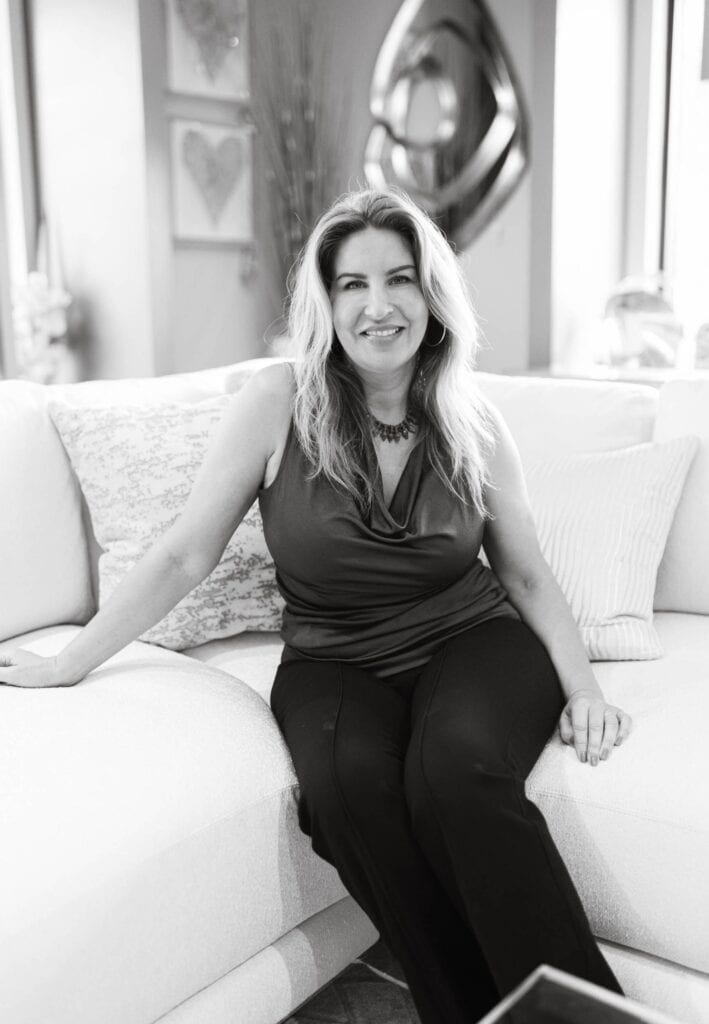 Modern woman sitting on a beige sofa in a well-designed interior.