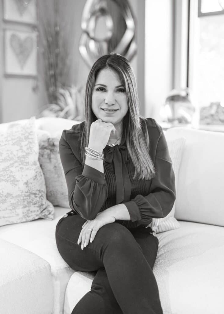 Portrait of a woman sitting on a sofa, professional interior designer, Brown Design Group branding.