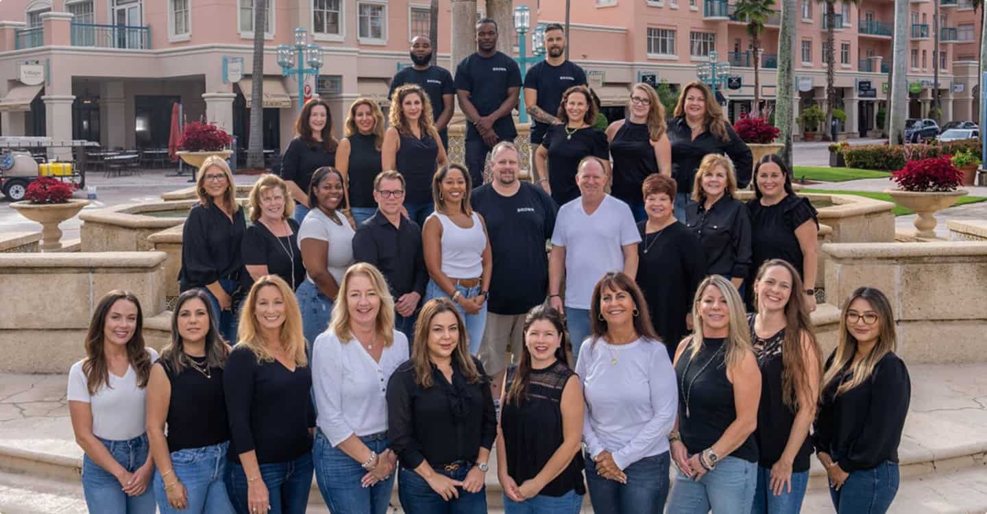 Group photo of the Brown Design Group team in an outdoor urban setting, showcasing professional interior and exterior design experts.